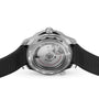 A close-up view of the back of an OMEGA Seamaster Diver 300M shows its automatic movement, Diver 300M markings, and a black rubber strap paired with a sleek black ceramic bezel.