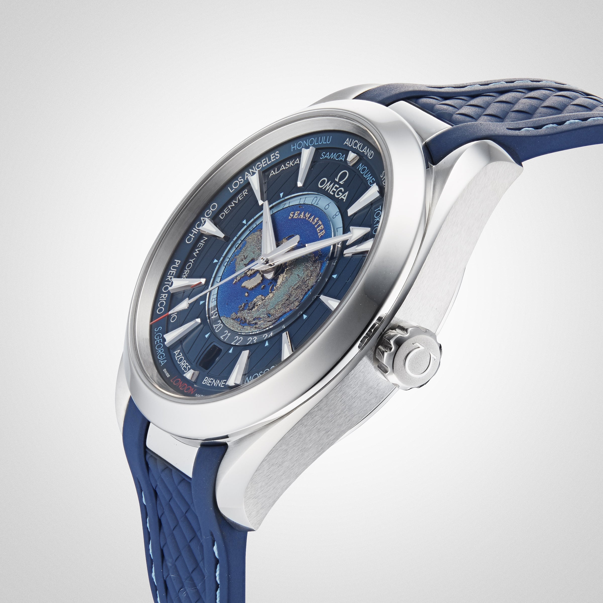 A close-up of the OMEGA Seamaster Aqua Terra 150M wristwatch with a blue strap and a detailed world map on the dial, displaying various international city names around the face.