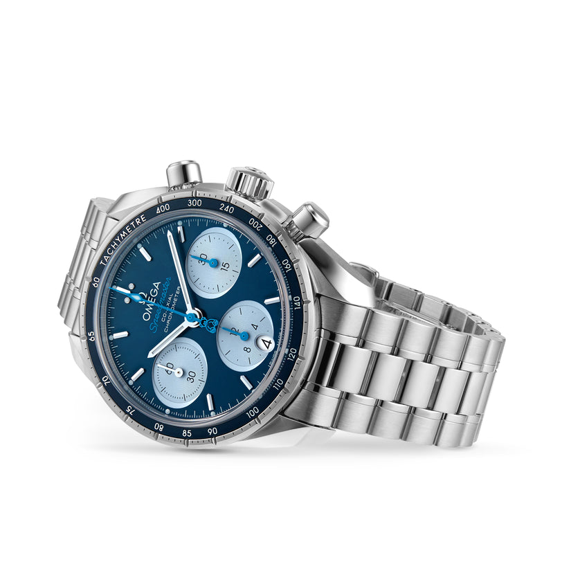 The OMEGA Speedmaster 38 Orbis Edition is a stainless steel chronograph wristwatch with a blue dial, three subdials, date window, tachymeter bezel, and a metal link bracelet.