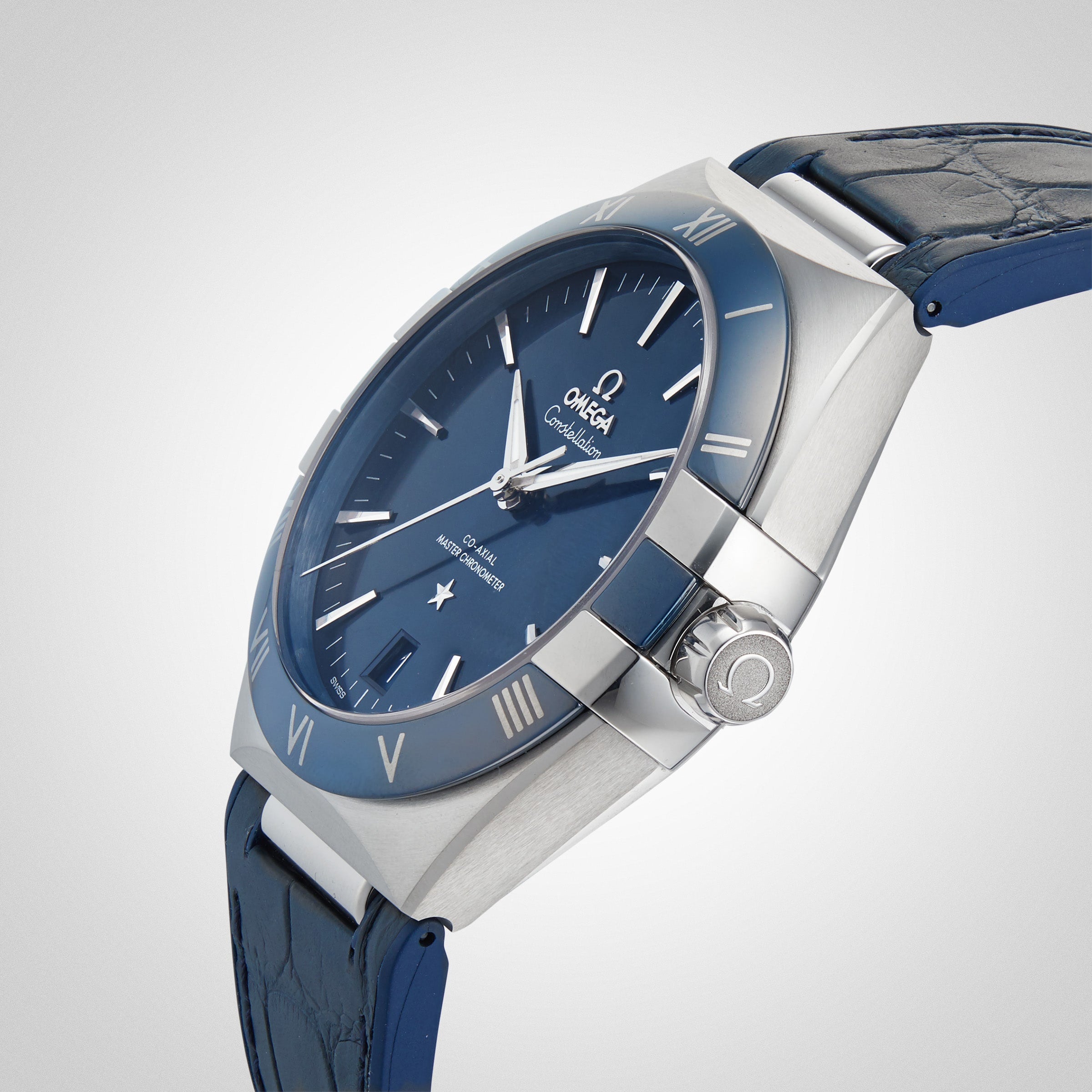 The OMEGA Constellation is a blue wristwatch featuring a leather strap, silver case, and Roman numerals on its blue ceramic bezel, shown against a plain white background.