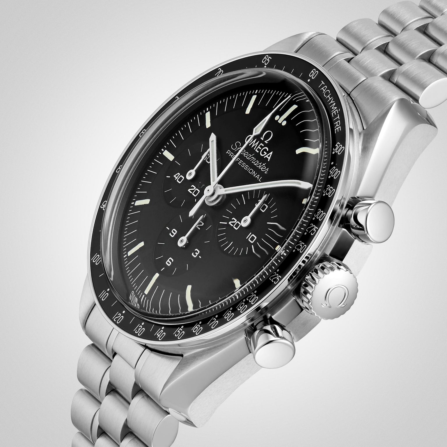 The OMEGA Speedmaster Moonwatch Professional in stainless steel features a black dial, chronograph subdials, tachymeter bezel, and metal bracelet—photographed on a light background as a tribute to the iconic 4th generation design.