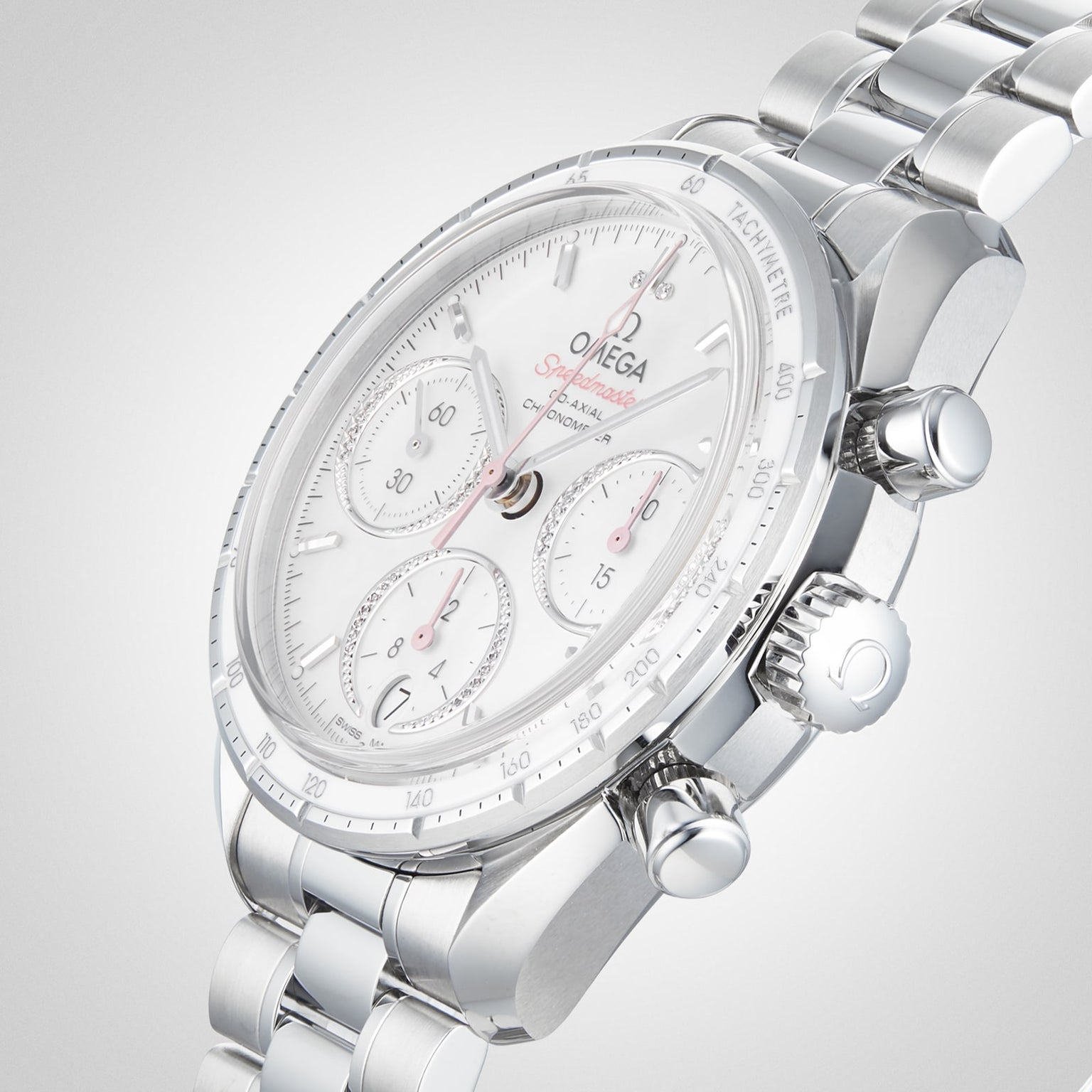 An OMEGA Speedmaster 38 stainless steel chronograph with a white dial, tachymeter bezel, and metal bracelet is displayed at an angle on a light gray background.