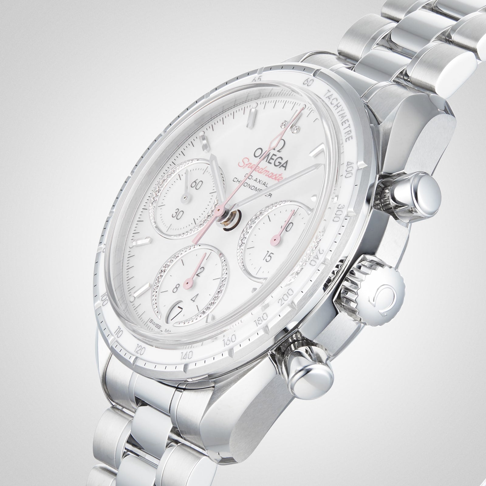 An OMEGA Speedmaster 38 stainless steel chronograph with a white dial, tachymeter bezel, and metal bracelet is displayed at an angle on a light gray background.
