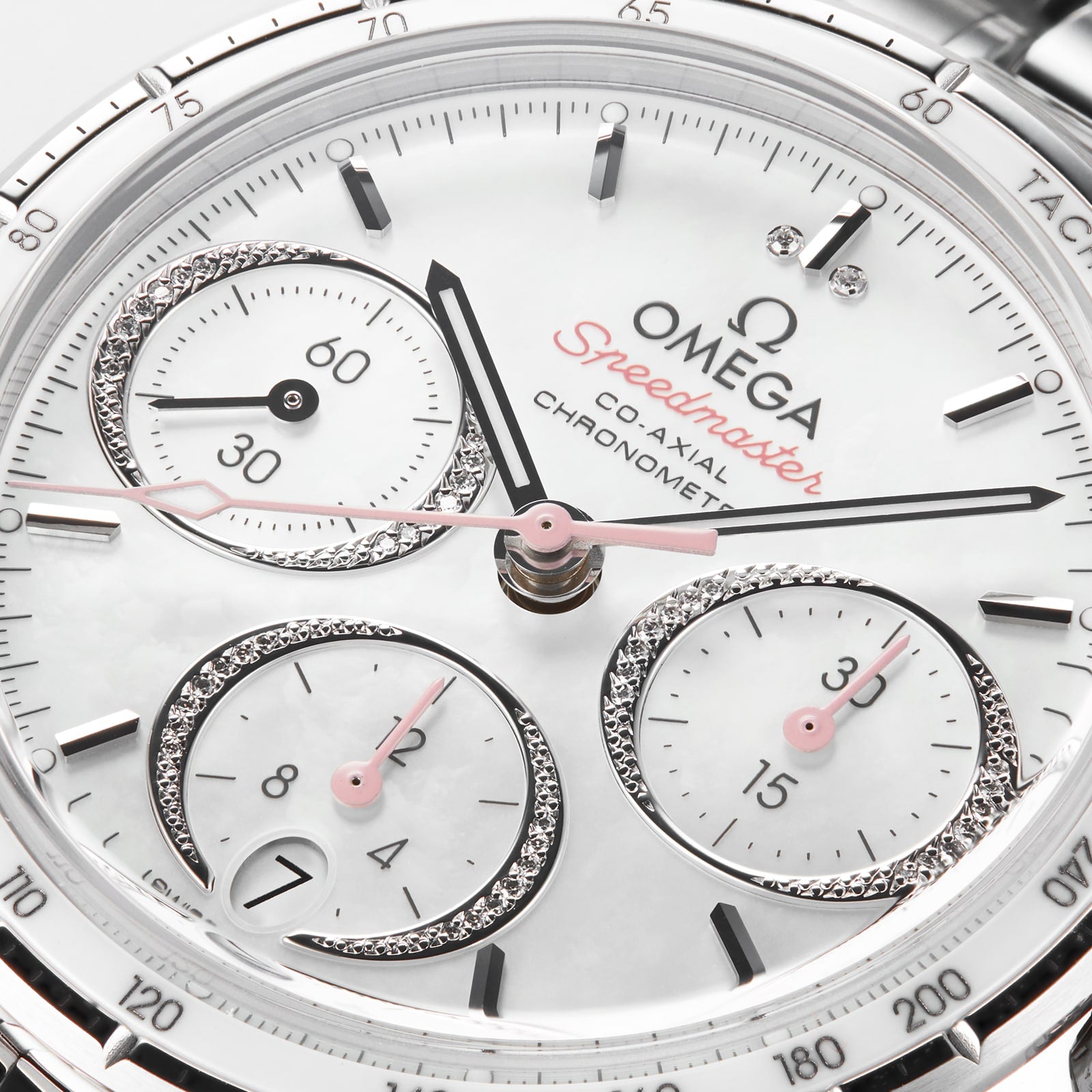 Close-up of the OMEGA Speedmaster 38 watch face, showing three subdials, diamond accents, chronograph labels, a tachymeter scale on the rim, and its precise 3330 calibre movement.