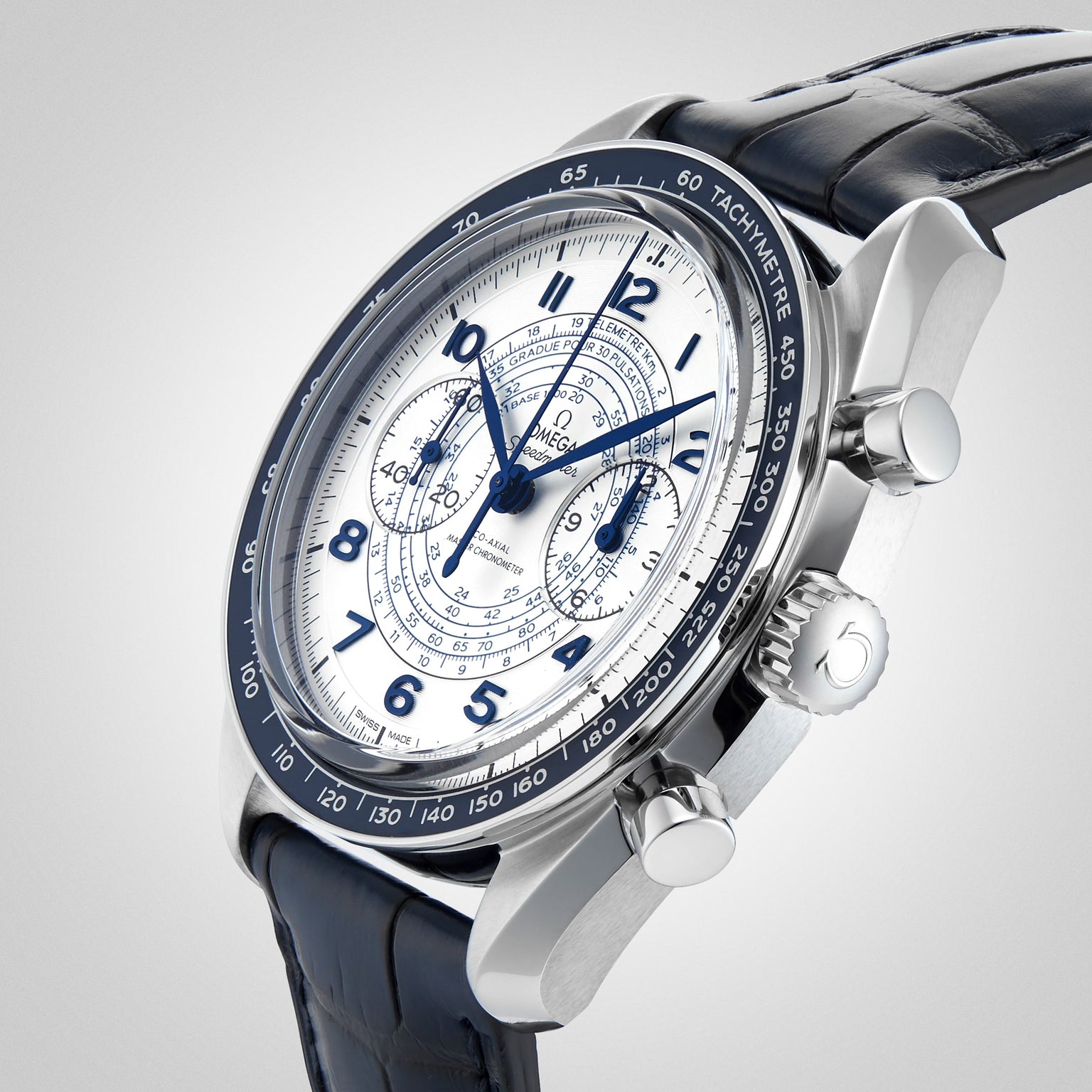 A close-up of the OMEGA Speedmaster Chronoscope, featuring a white dial, blue hands and numerals, three sub-dials, a tachymeter bezel, and a blue leather strap in 1940s-inspired design.