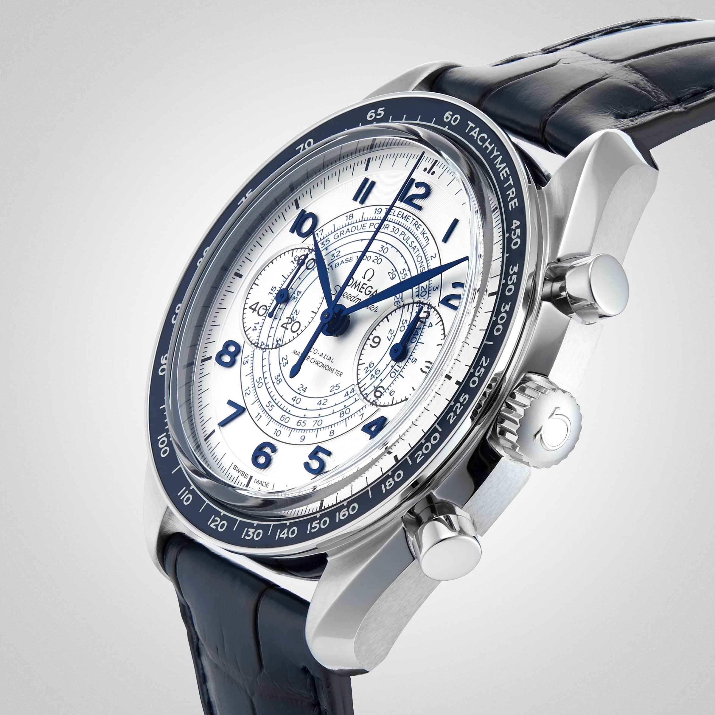 A close-up of the OMEGA Speedmaster Chronoscope, featuring a white dial, blue hands and numerals, three sub-dials, a tachymeter bezel, and a blue leather strap in 1940s-inspired design.