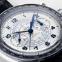 Close-up of the OMEGA Speedmaster Chronoscope, featuring a white dial with blue hands and numerals, tachymeter bezel, 1940s-inspired chronograph sub-dials, and a black leather strap.