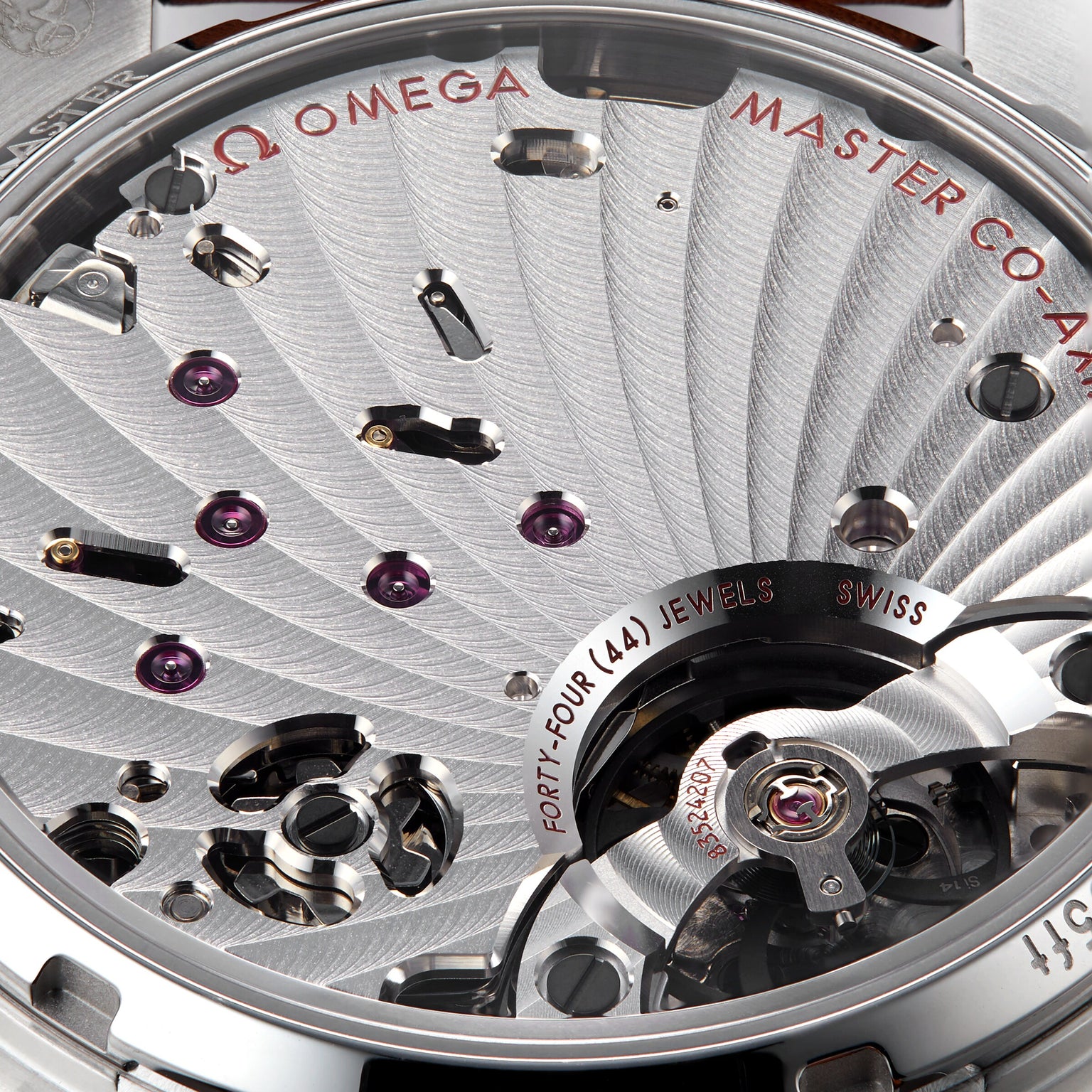 Close-up of the OMEGA Speedmaster Chronoscope movement displaying mechanical details, MASTER CO-AXIAL text, and FORTY-FOUR (44) JEWELS SWISS engraved—signifying Speedmaster precision.
