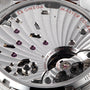 Close-up of the OMEGA Speedmaster Chronoscope movement displaying mechanical details, MASTER CO-AXIAL text, and FORTY-FOUR (44) JEWELS SWISS engraved—signifying Speedmaster precision.