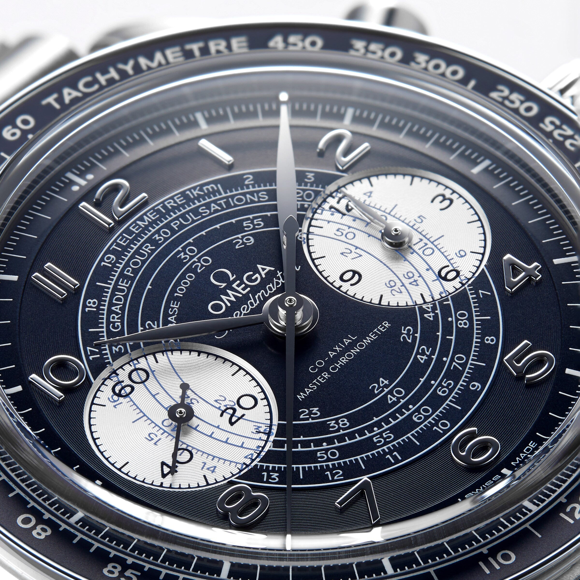 Close-up of the OMEGA Speedmaster Chronoscope wristwatch, featuring a detailed chronograph dial with silver hands, white subdials, and 9908 calibre movement set against a dark background.