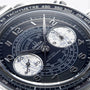 Close-up of the OMEGA Speedmaster Chronoscope wristwatch, featuring a detailed chronograph dial with silver hands, white subdials, and 9908 calibre movement set against a dark background.