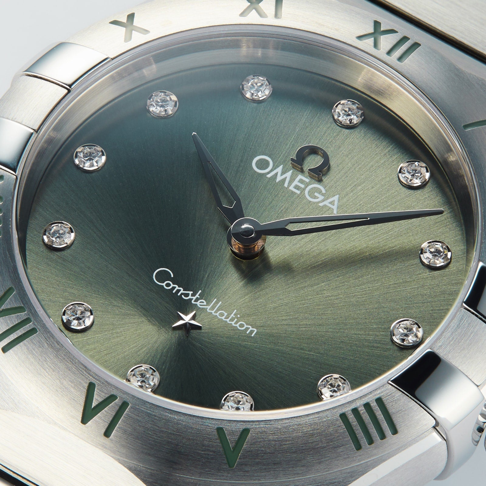 Close-up of the OMEGA Constellation watch featuring a matcha green dial, diamond hour markers, and silver Roman numerals on the bezel in a stainless steel case.