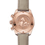 Back view of the OMEGA Speedmaster 38 watch, showcasing its engraved seahorse emblem and specifications on the 18K Sedna™ gold case back, paired with a light leather strap.