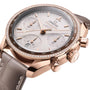 The OMEGA Speedmaster 38 is an 18K Sedna™ gold chronograph with a rose gold case, tachymeter bezel, diamond accents, Co-Axial Calibre 3330 movement, and a grey leather strap.