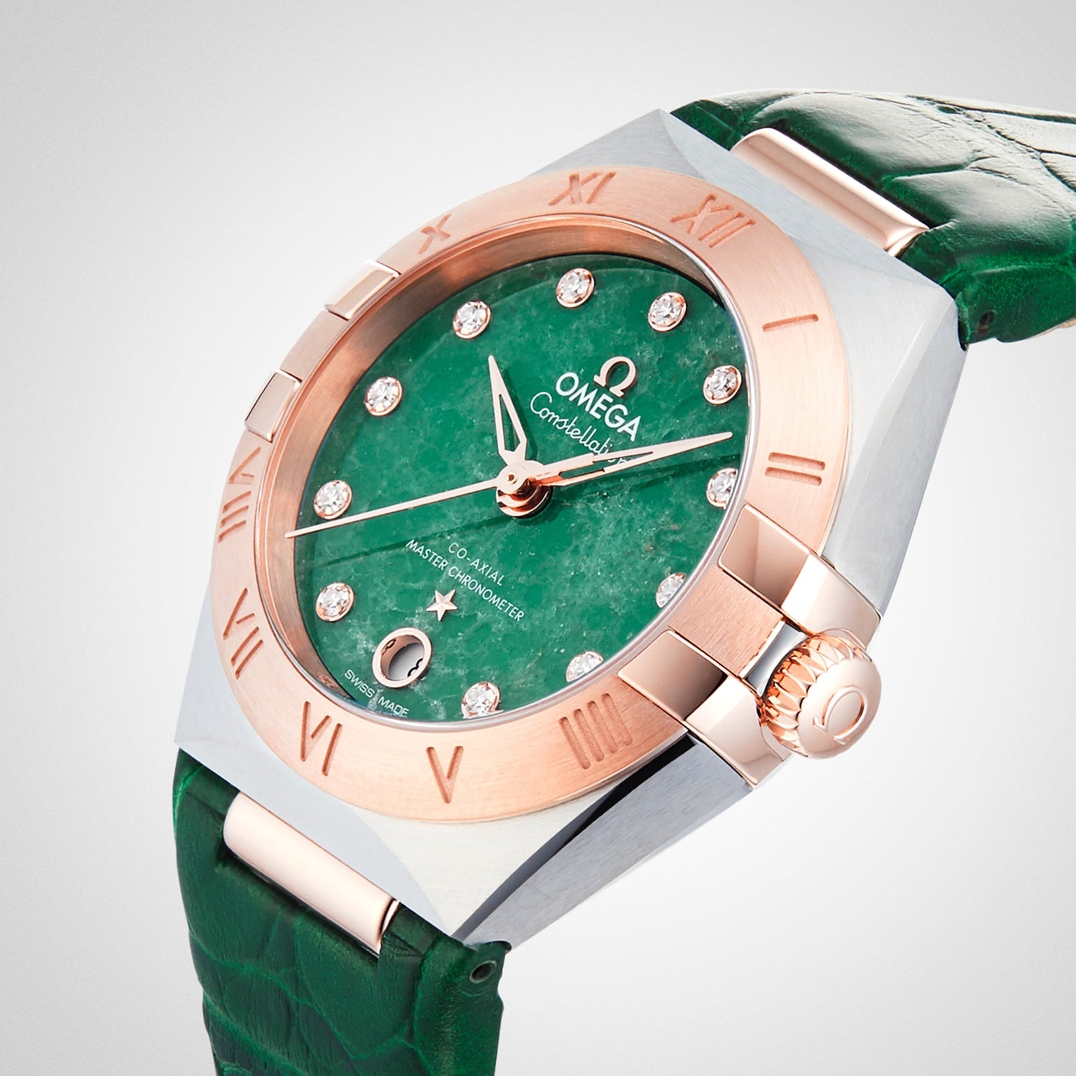 The OMEGA Constellation features a green Aventurine dial with diamond hour markers, an 18K Sedna™ gold bezel, and a matching green leather strap, showcased against a plain background.