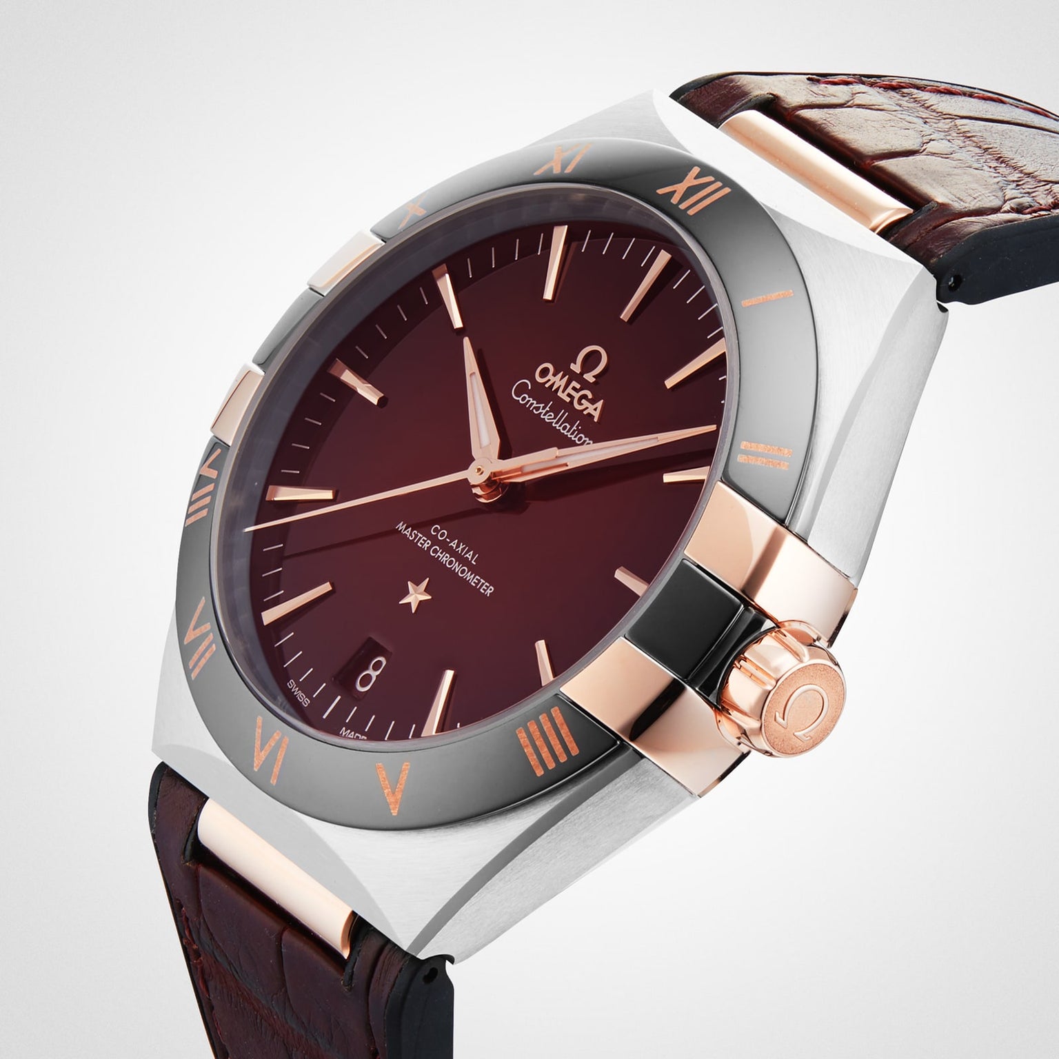 The OMEGA Constellation is a luxury watch with a brown dial, rose gold accents, Roman numerals, and a brown leather strap, featuring Master Chronometer certified 8900 calibre and classic Constellation heritage.