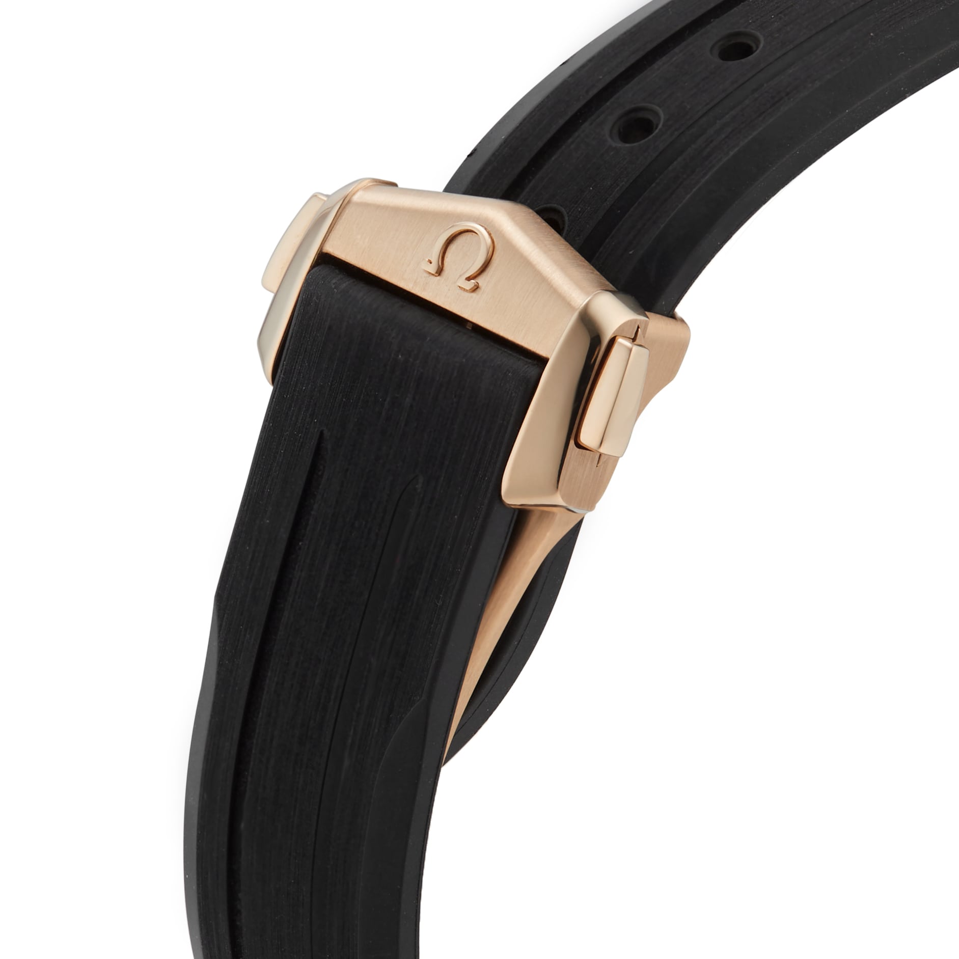 Close-up of a gold clasp engraved with the OMEGA logo on a black rubber strap—an elegant detail from the Speedmaster Moonwatch Professional.