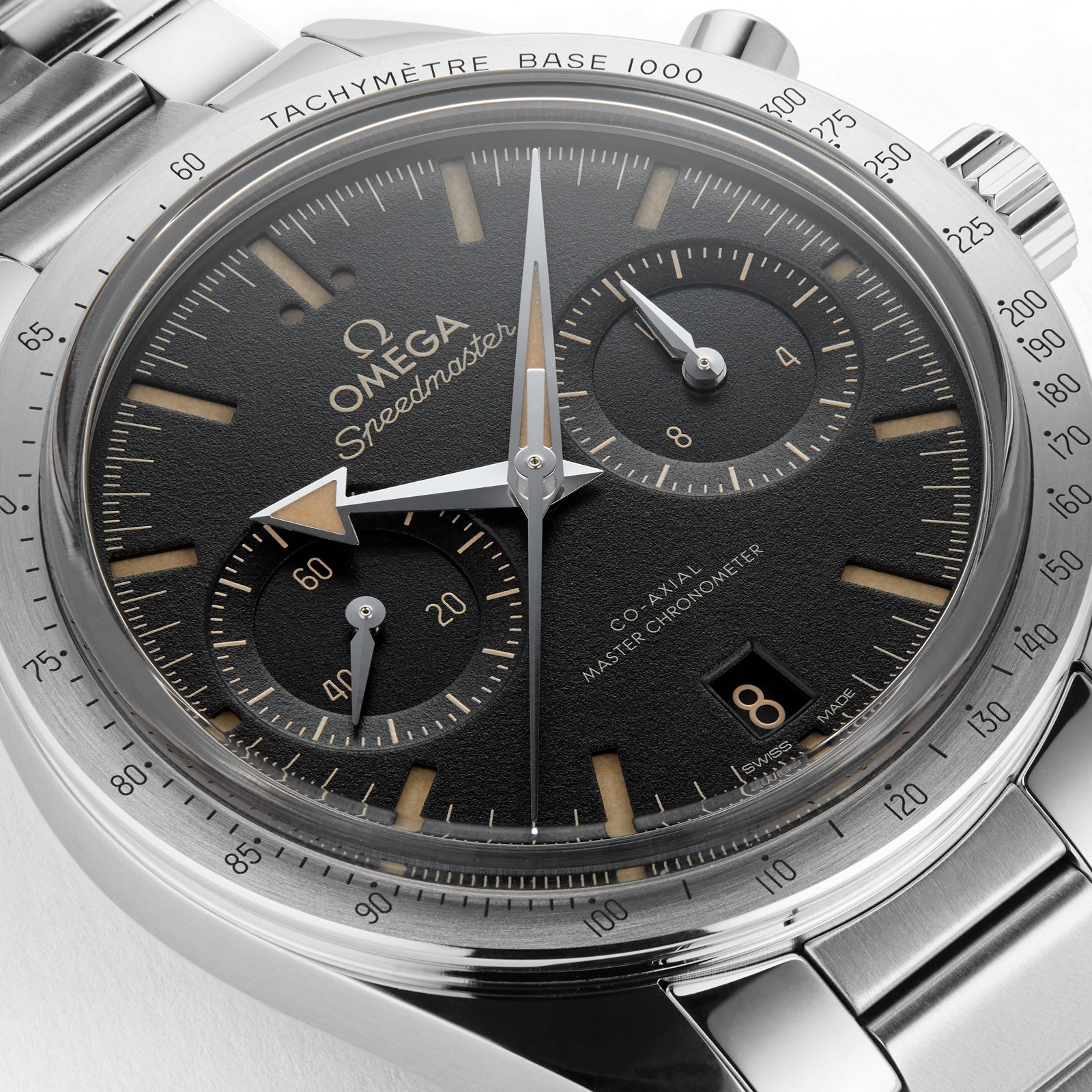 Close-up of an OMEGA Speedmaster 57 with a black dial, stainless steel case and bracelet, three subdials, tachymeter bezel, Co-Axial Master Chronometer movement; time shown is 10:10:34 and date is the 8th.