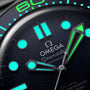 Close-up of the OMEGA Seamaster Diver 300M James Bond 007 60th Anniversary watch face, with luminescent hands, hour markers, textured black dial, detailed branding, and Master Co-Axial 8806 movement.