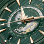 Close-up of an OMEGA Seamaster Aqua Terra 150M with a green and gold world map dial, gold hour markers, stainless steel case, and city names on the outer edge.