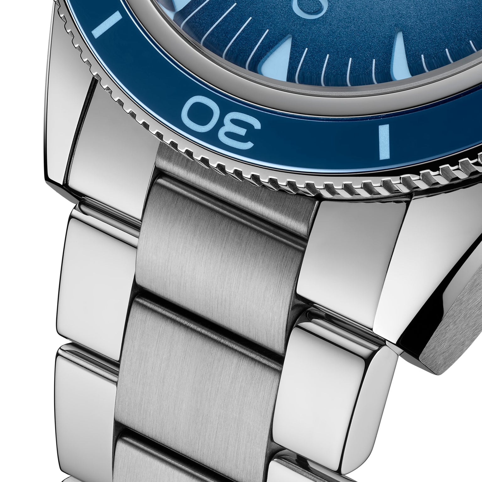 Close-up of the OMEGA Seamaster 300 Summer Blues stainless steel bracelet and case, featuring a blue bezel and detailed links, with part of the watch face and numerals, crafted to Master Chronometer standards.