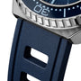 Close-up of the OMEGA Seamaster Ploprof 1200M Summer Blue, showcasing its blue bezel with minute markers and a blue rubber strap featuring rectangular cutouts.