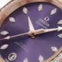 Close-up of the OMEGA Seamaster Aqua Terra Shades watch, showcasing a lavender dial, diamond hour markers, 18K Sedna™ Gold hands, and a date window at 6 o’clock.