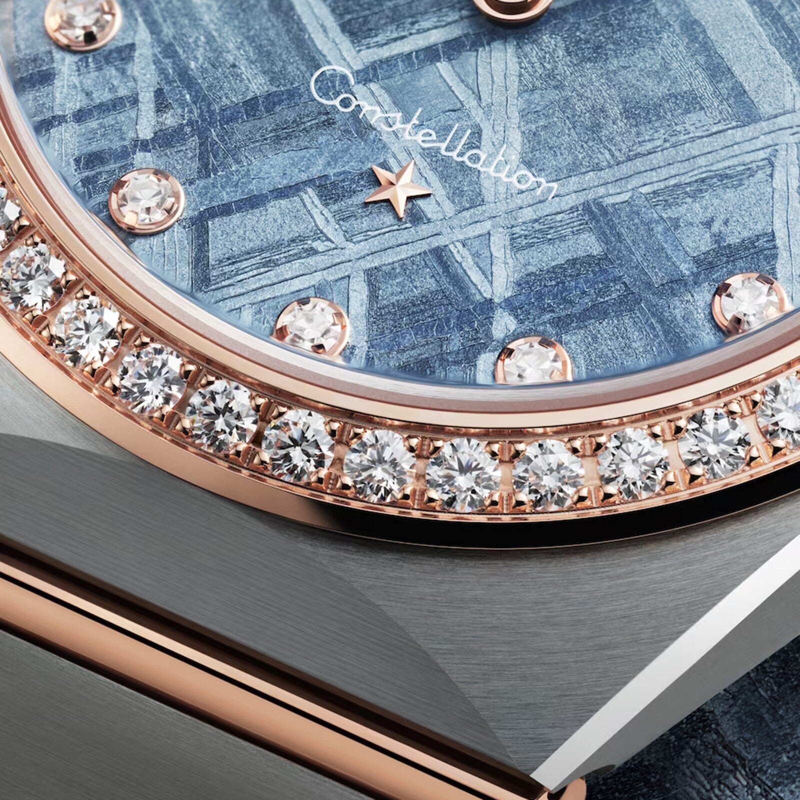 Close-up of the OMEGA Constellation watch, showcasing a blue patterned meteorite dial, diamonds, and an 18K Sedna Gold bezel.