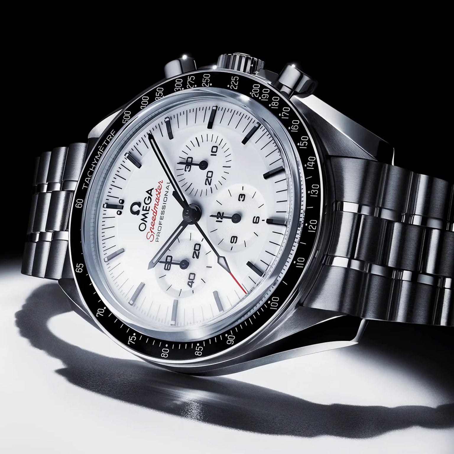 The OMEGA Speedmaster Moonwatch Professional features a white dial, black tachymeter bezel, and three subdials, powered by the OMEGA 3861 calibre on a metal bracelet, displayed against a white and black background.