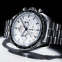 The OMEGA Speedmaster Moonwatch Professional features a white dial, black tachymeter bezel, and three subdials, powered by the OMEGA 3861 calibre on a metal bracelet, displayed against a white and black background.