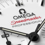 Close-up of a white OMEGA Speedmaster Moonwatch Professional dial, featuring black hands, indices, red Speedmaster text, and the iconic chronograph design.