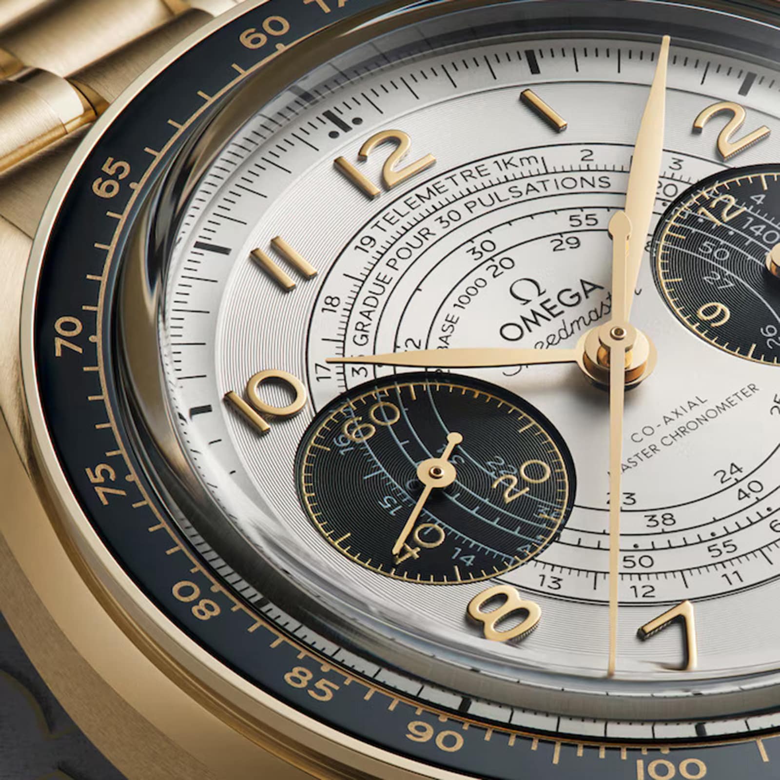 Close-up of the OMEGA Speedmaster Chronoscope Paris 2024 Olympics, featuring gold hands, three subdials, and tachymeter, telemeter, and pulsometer scales—Master Chronometer from the Speedmaster collection.