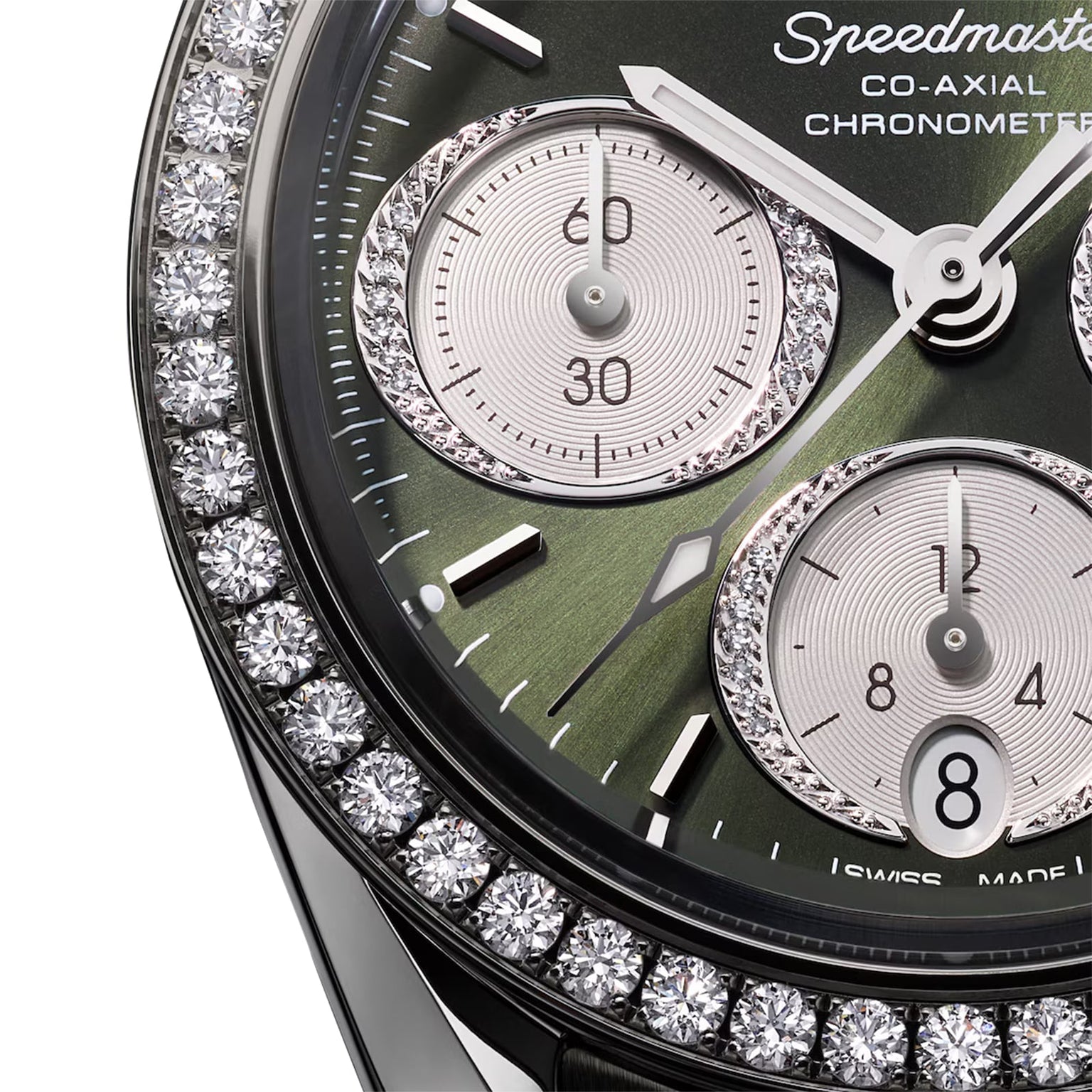 Close-up of the OMEGA Speedmaster 38 wristwatch featuring a green dial, diamond bezel, three subdials, and the OMEGA Co-Axial Calibre 3330 Chronometer label.