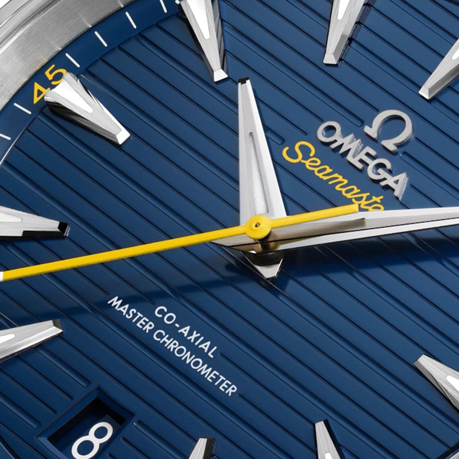 Close-up of the OMEGA Seamaster Aqua Terra 150M watch face, featuring a blue textured dial, silver hour markers, yellow second hand, date at 8 o’clock, and powered by the Co-Axial Master Chronometer Calibre 8900 in stainless steel.