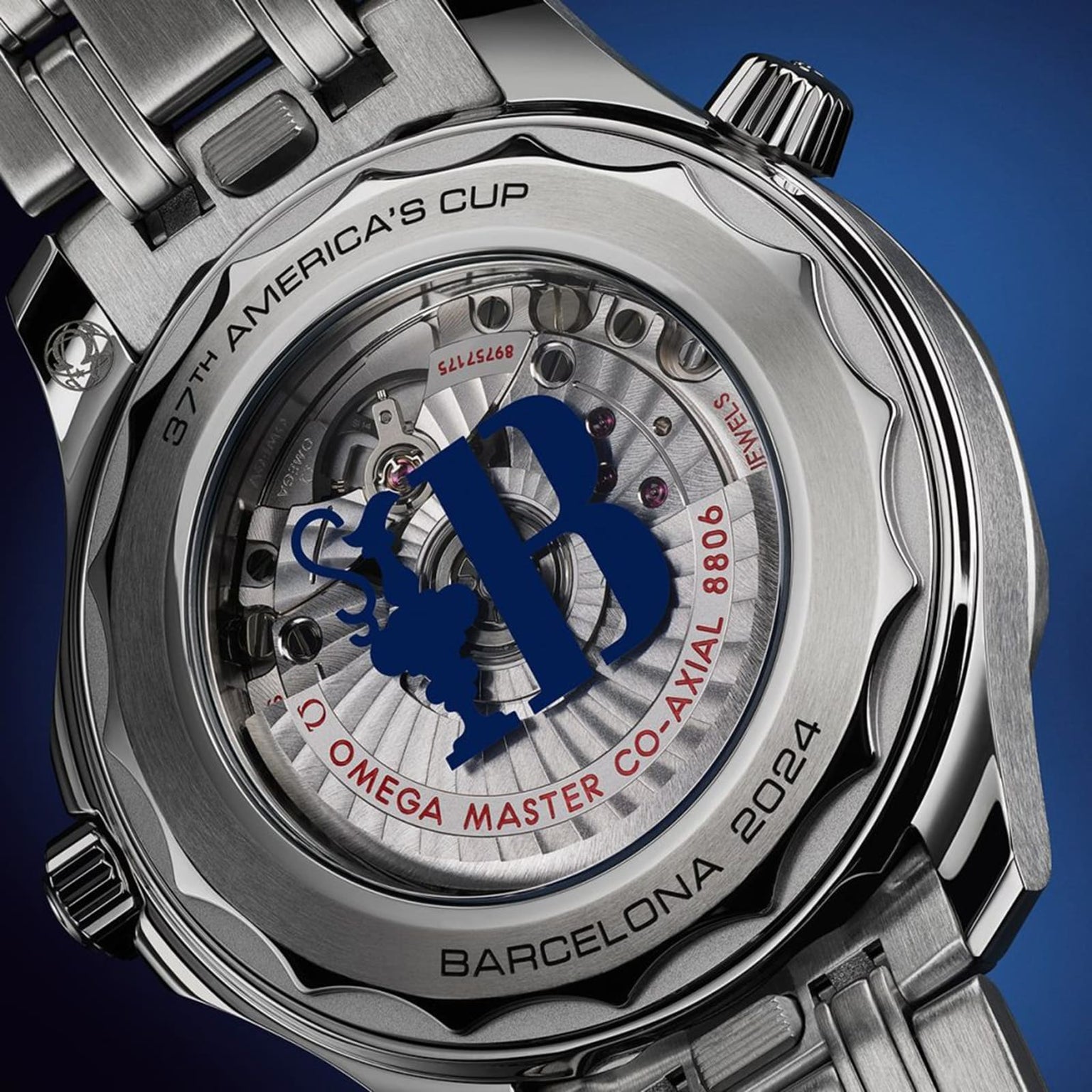 Close-up of the OMEGA Seamaster Diver Americas Cup 300M, showing the 37th Americas Cup logo, visible movement parts, and BARCELONA 2024 engraved on the case back.