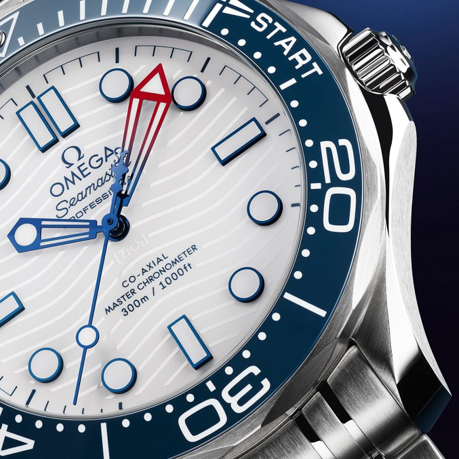 Close-up of the OMEGA Seamaster Diver Americas Cup 300M, featuring a white textured dial, blue bezel, blue markers, red-tipped second hand, and 300m/1000ft water resistance—an icon tied to the Americas Cup.