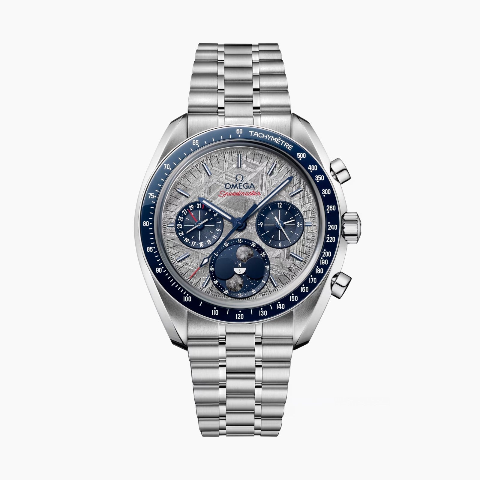 An OMEGA Speedmaster Moonphase Meteorite watch in stainless steel features a blue tachymeter bezel, silver textured dial with chronograph subdials, and a metal bracelet, displayed against a white background.