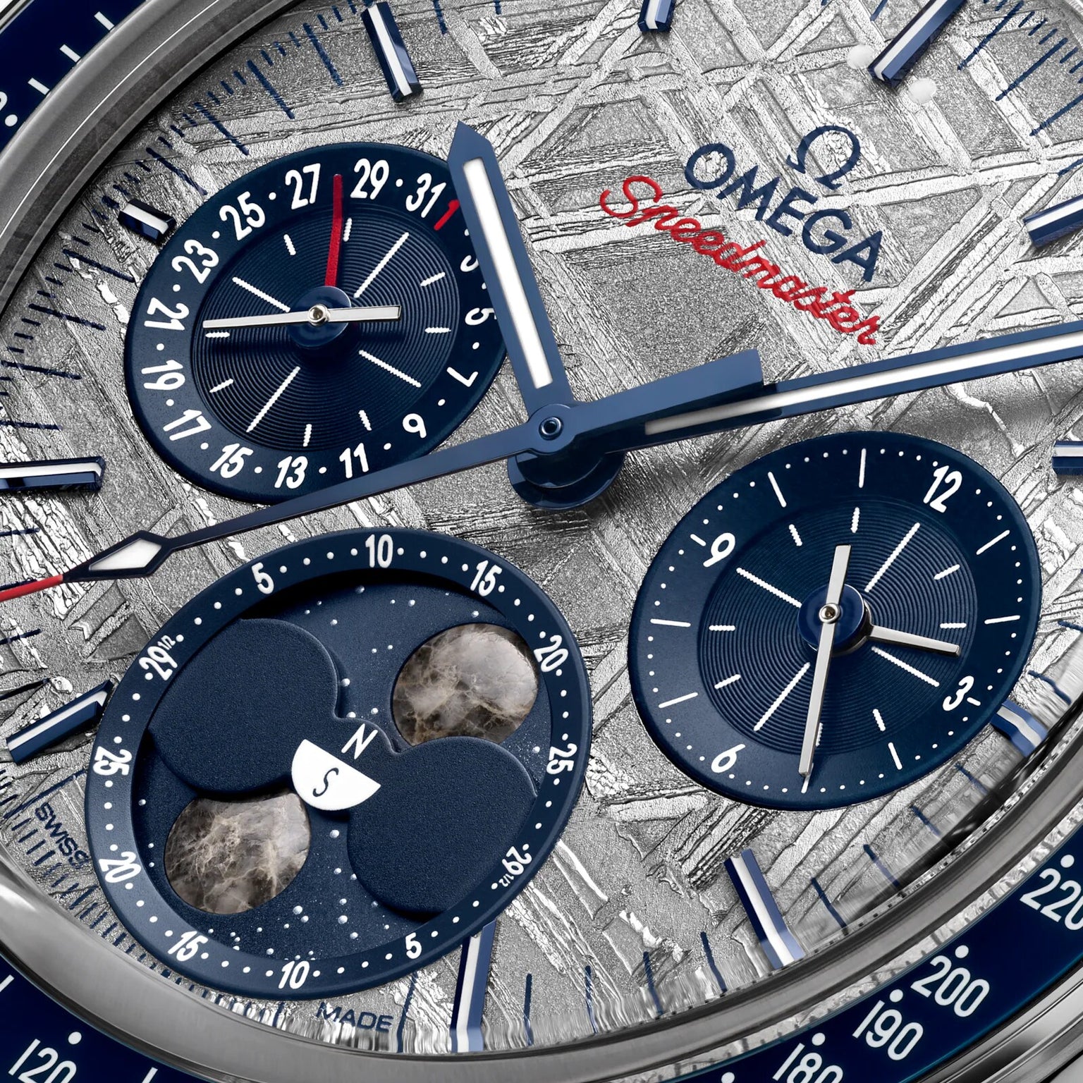 Close-up of the OMEGA Speedmaster Moonphase Meteorite watch face, highlighting chronograph subdials, a date indicator, and moonphase complication set against a textured meteorite dial.