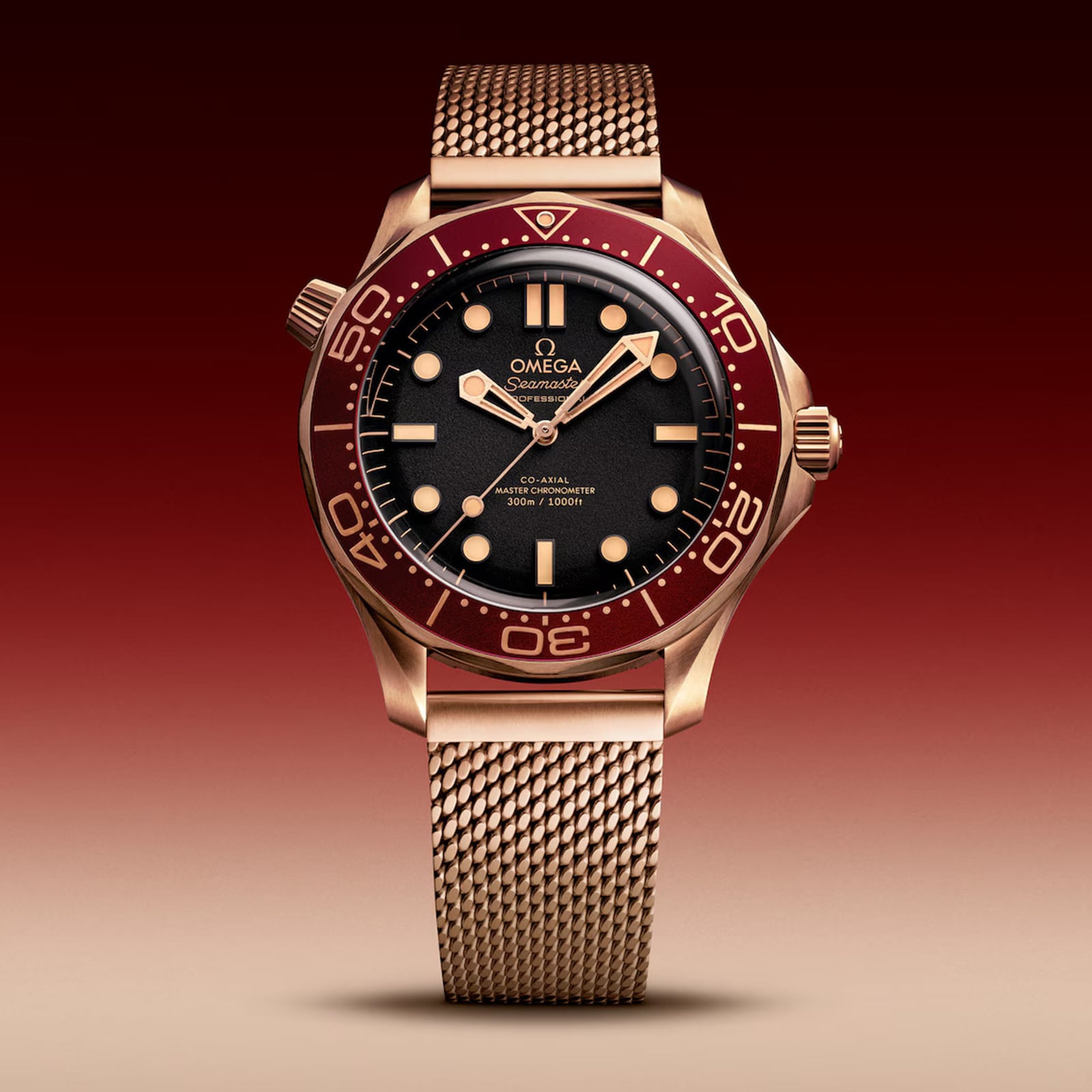 An OMEGA Seamaster Diver 300M with bronze gold case, mesh strap, dark dial, and burgundy bezel, featuring Co-Axial Master Chronometer precision, is shown against a gradient red background.