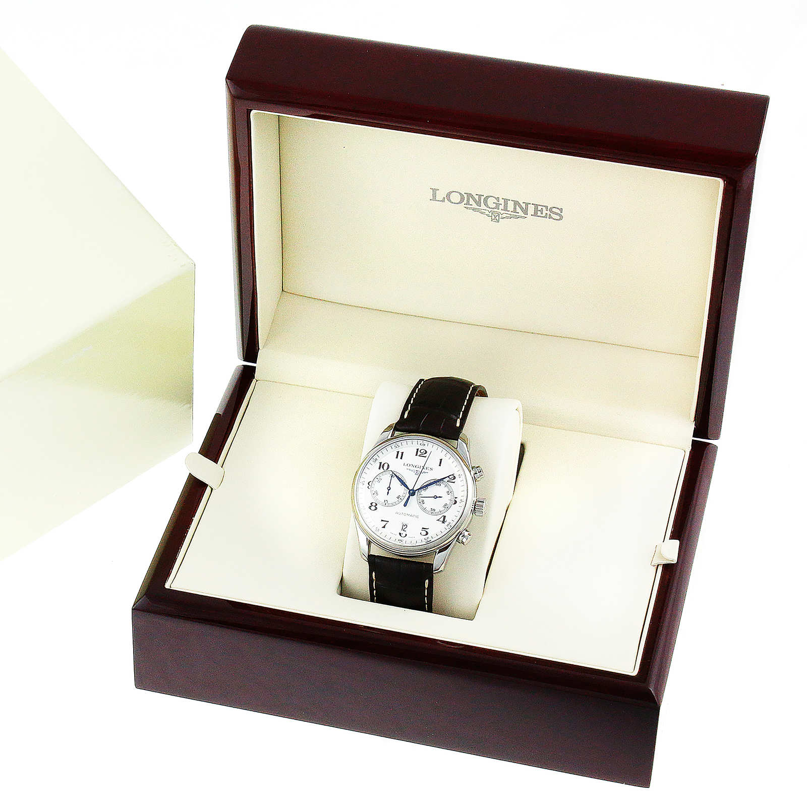 The Longines Master Collection Chronograph wristwatch, with blued steel hands and a black leather strap, is displayed in an open cream and brown presentation box, exuding classic elegance.