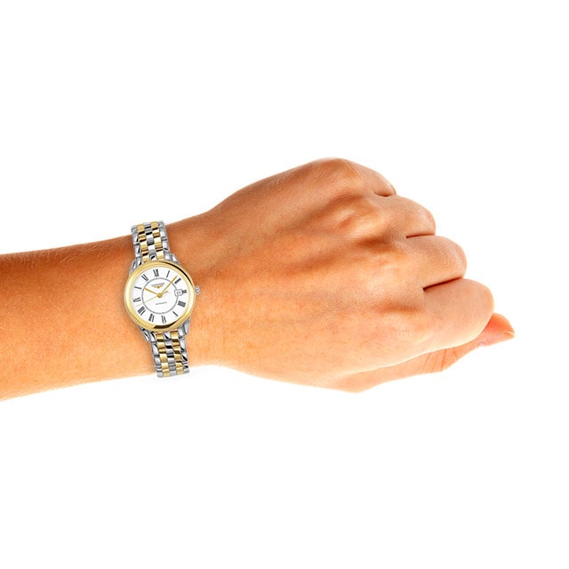 A hand wearing the Longines Flagship silver wristwatch with a white clock face, isolated on a white background.