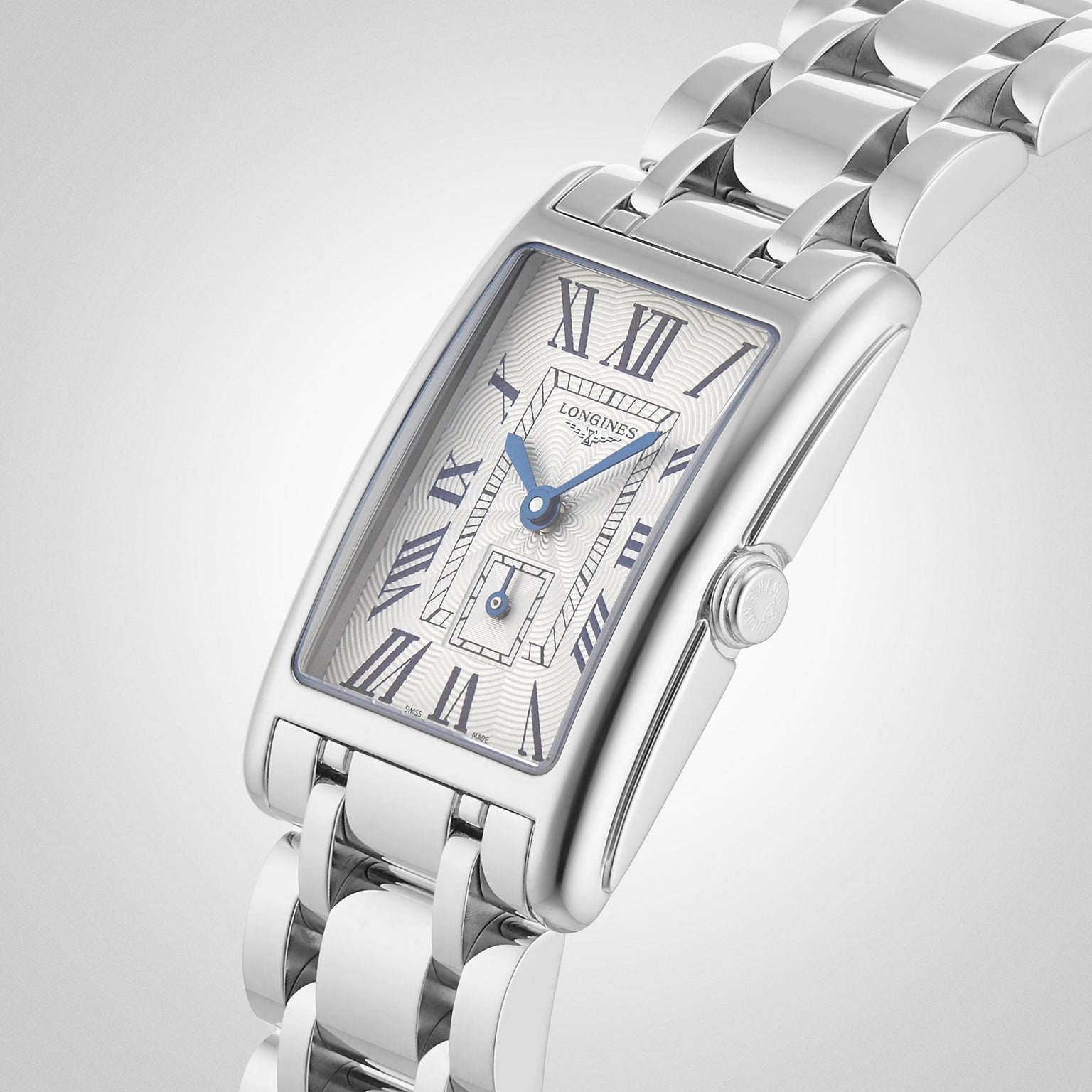 The Longines DolceVita wristwatch features a rectangular silver case, white dial with blue Roman numerals, and a metal link bracelet, combining elegant design with precise quartz movement.