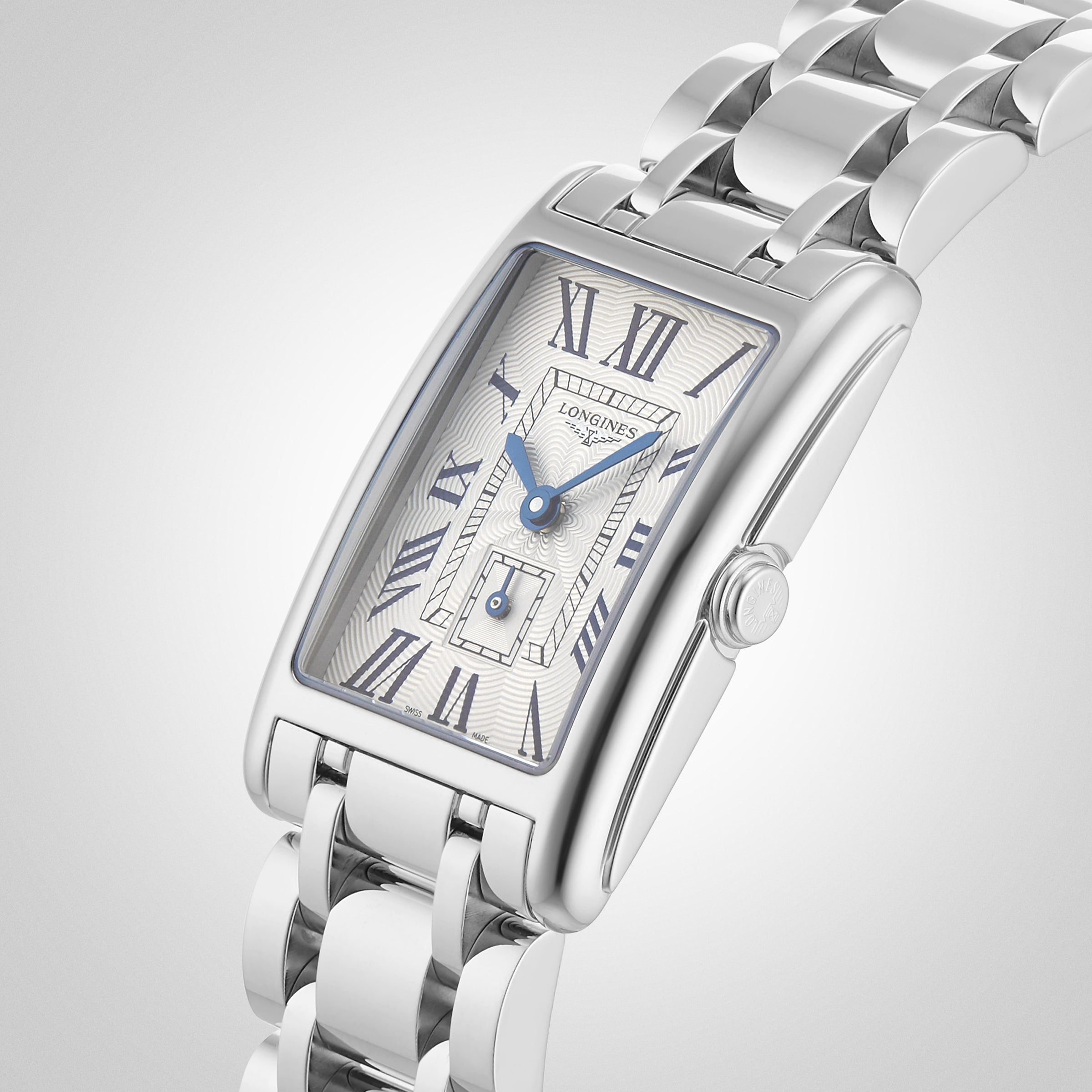 The Longines DolceVita wristwatch features a rectangular silver case, white dial with blue Roman numerals, and a metal link bracelet, combining elegant design with precise quartz movement.