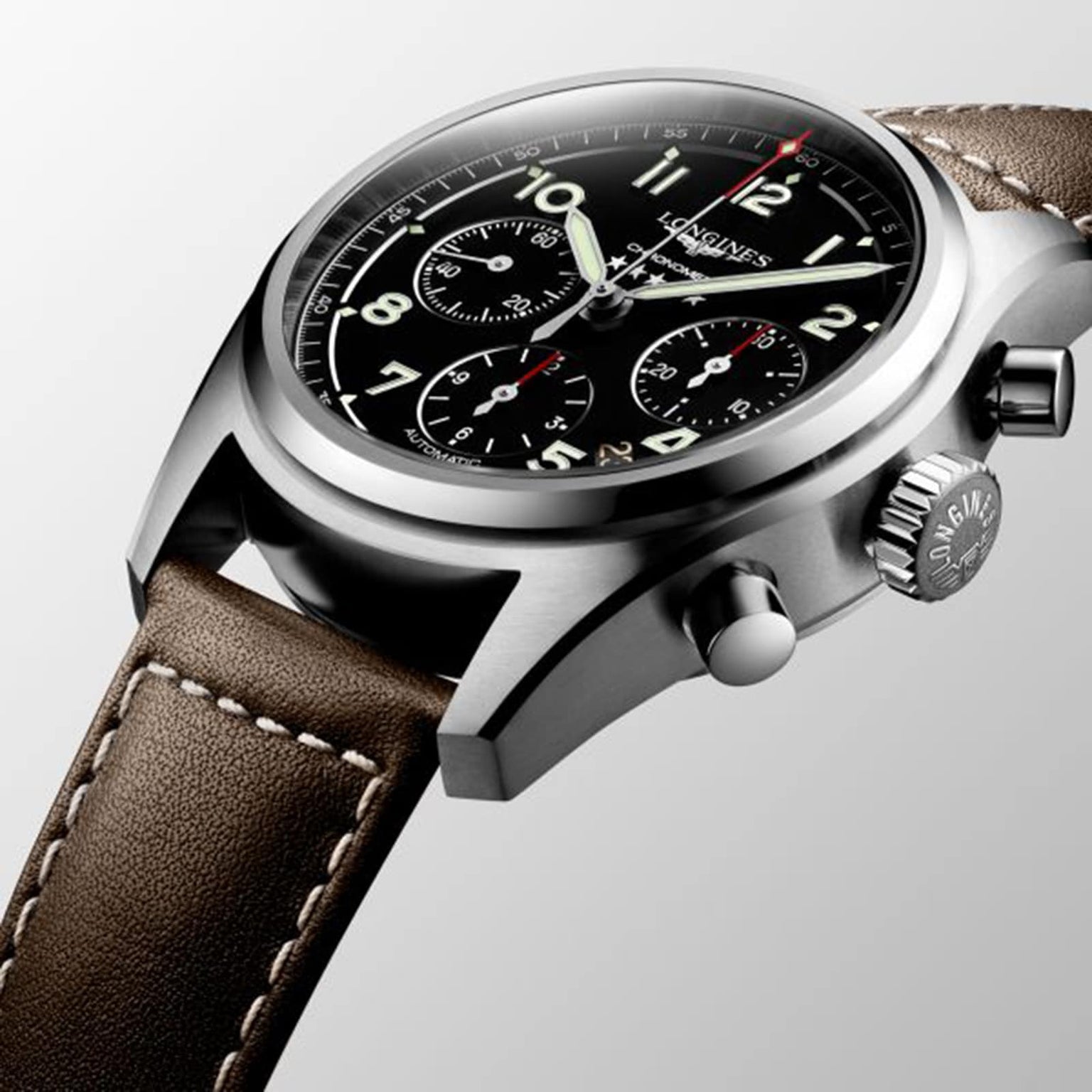 A close-up of the Longines Spirit Chronograph shows a brown leather strap, stainless steel case, black dial with three sub-dials, the Longines logo, and features the precise L688.4 calibre movement.