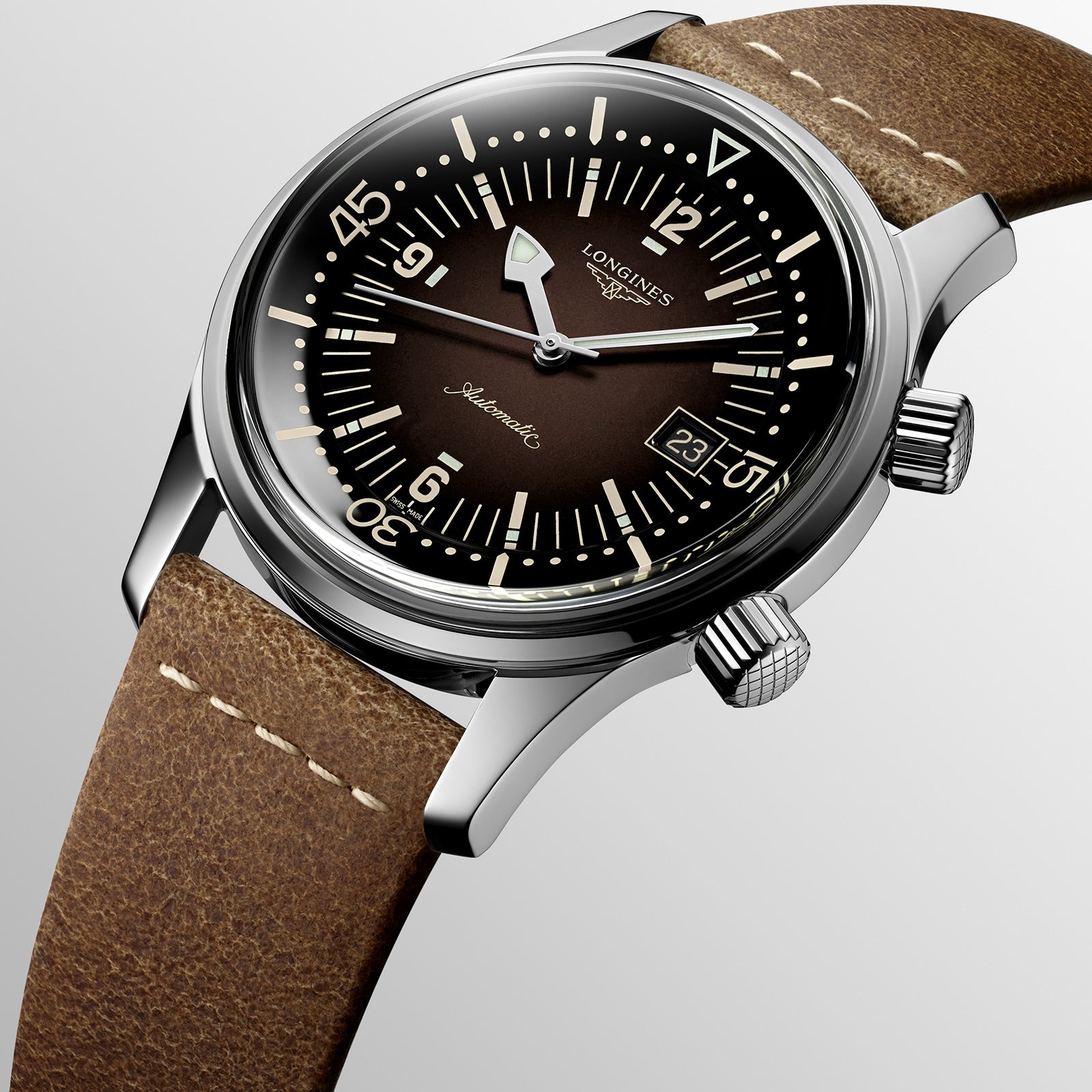 A close-up of the Longines Legend Diver watch, featuring a brown dial with luminous markers, twin crowns, date display, brown leather strap, and powered by the reliable L888 calibre movement.