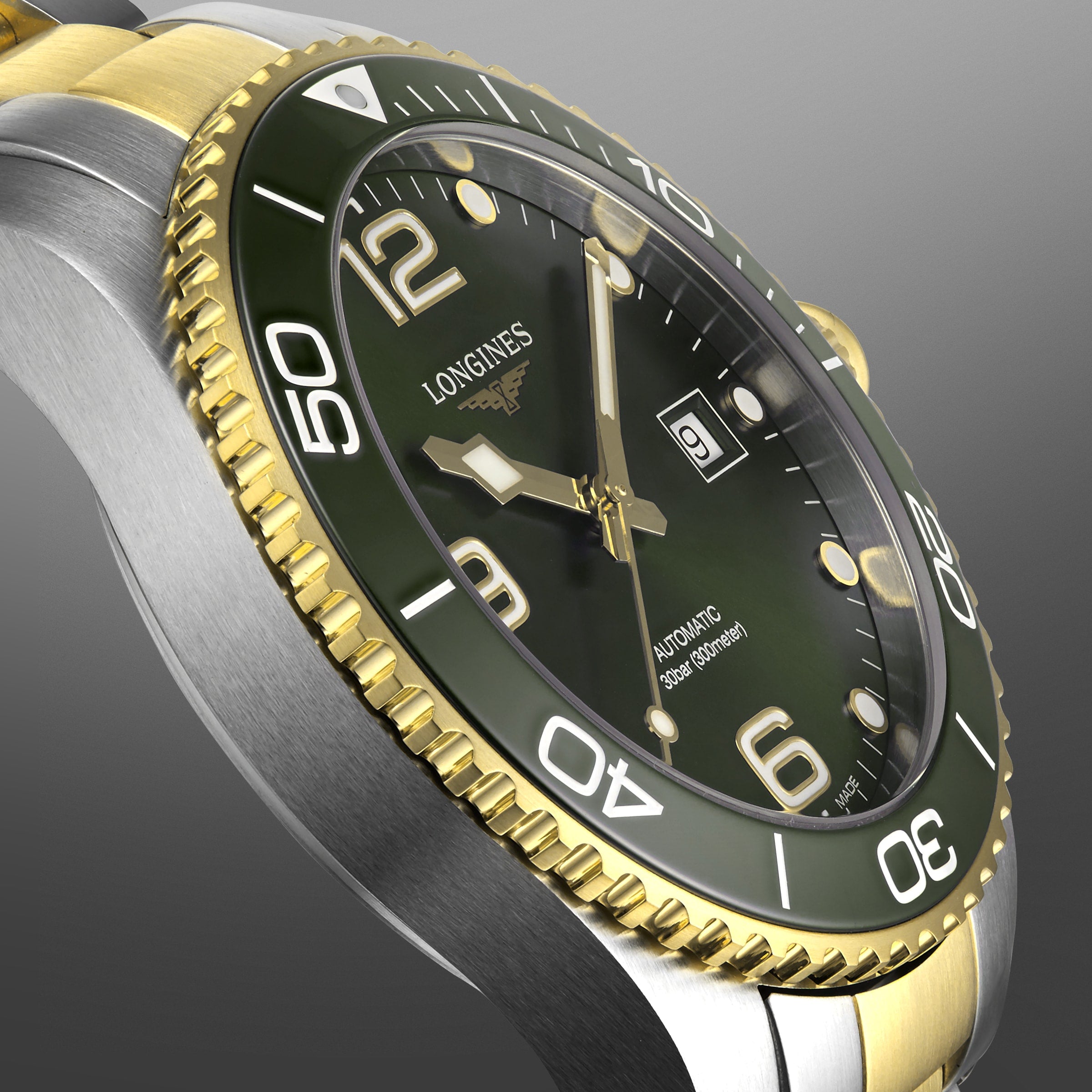 Close-up of the Longines HydroConquest with a green dial, gold and silver bezel, date at 3 o’clock, and 300m water resistance.