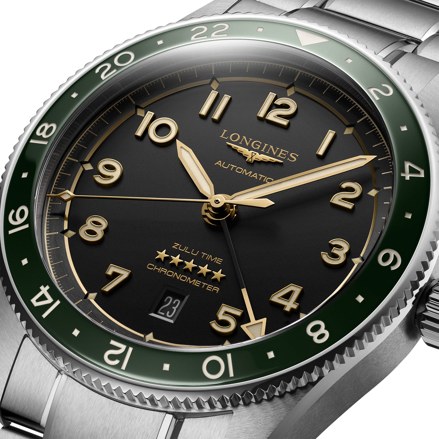 The Longines Spirit Zulu Time is a 42mm stainless steel automatic watch featuring a green bezel, anthracite dial, gold-tone hands and numerals, a date window at 6 o’clock, and ‘Zulu Time’ above the date.