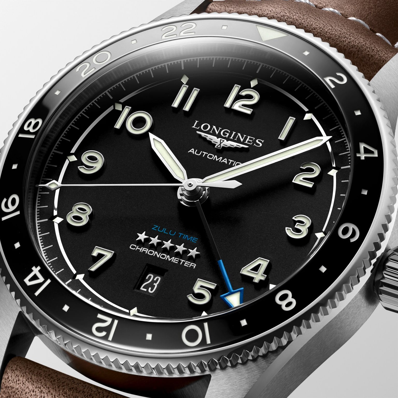 Close-up of the Longines Spirit Zulu Time automatic watch with a black dial, luminous numerals, date display, brown leather strap, stainless steel case, multiple time zone tracking, and chronometer certification.