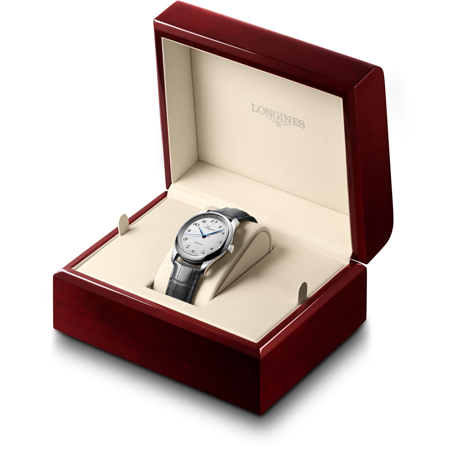 The Longines Master Collection wristwatch, with a black leather strap and white face, is shown in an open cream-colored and dark wood Longines presentation box.