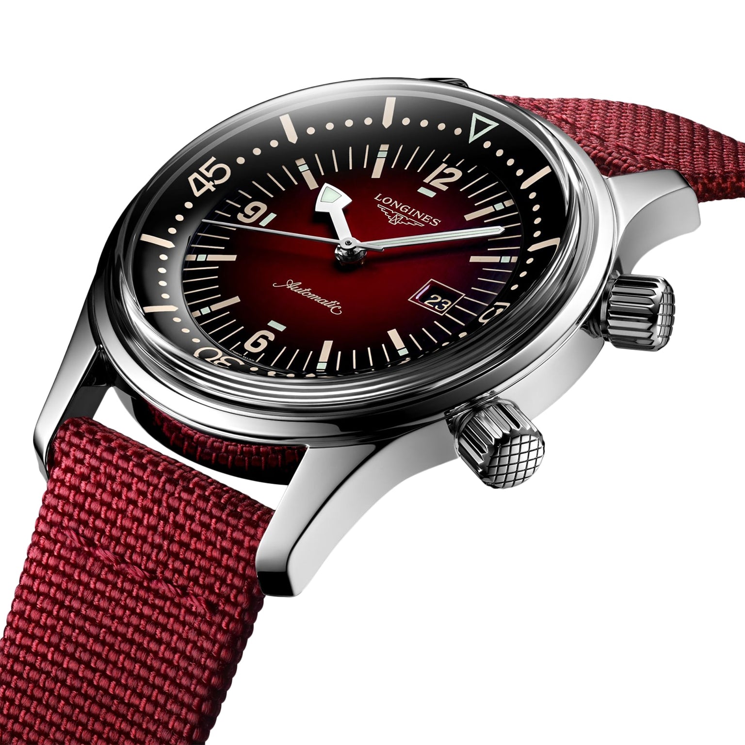 A close-up of the Longines Legend Diver watch, featuring a burgundy gradient dial, silver hands, date window, and a textured red fabric strap.
